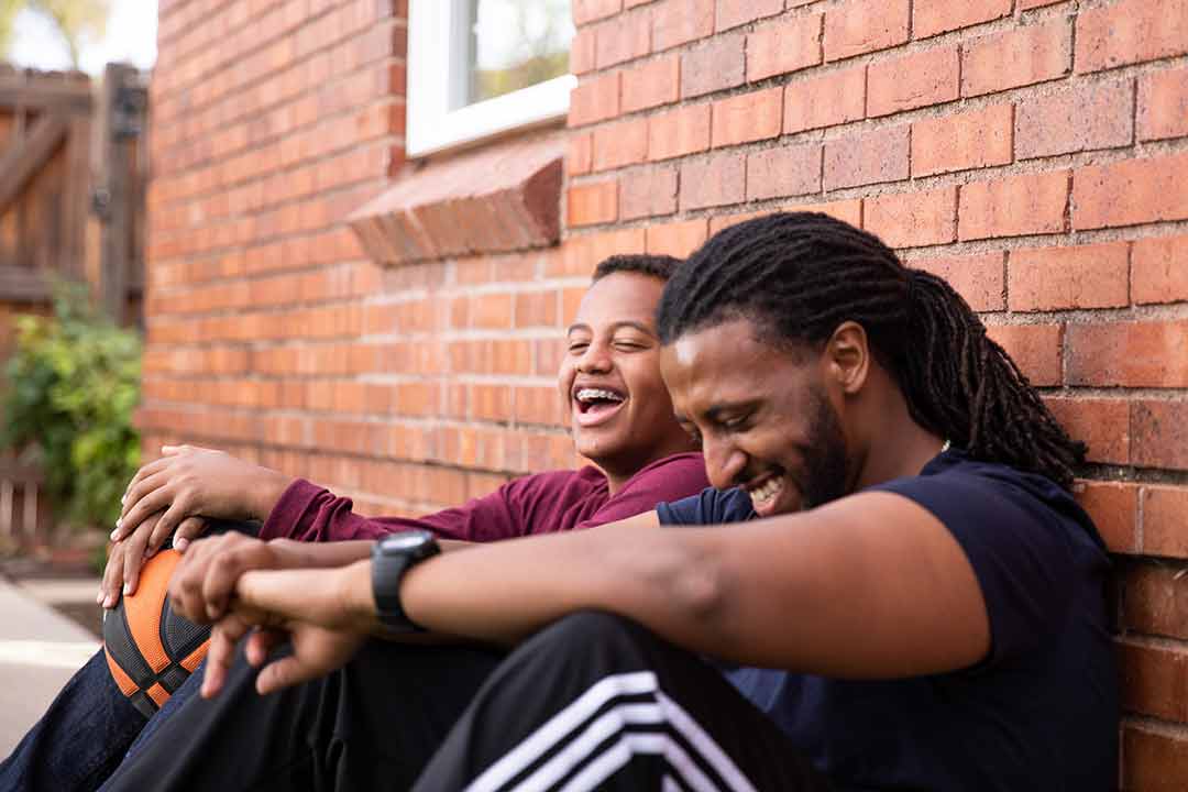 Mentor and Mentee sitting against a wall